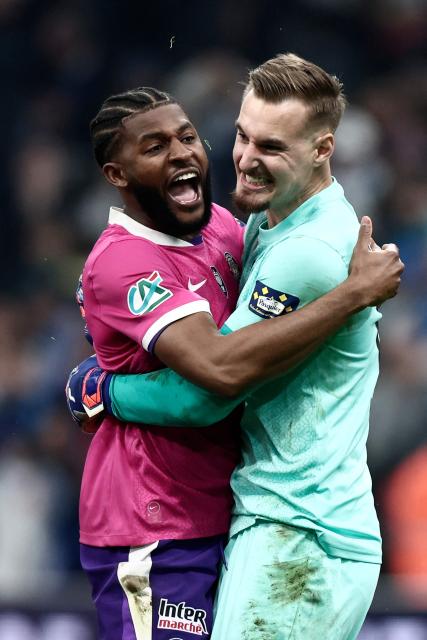 Toulouse's French goalkeeper #01 Guillaume Restes and teammate celebrate their victory at the end of the French Cup quarter final football match between Olympique de Marseille (OM) and Toulouse FC at the Stade Velodrome stadium in Marseille, southern France on March 4, 2026. (Photo by Thibaud MORITZ / AFP)