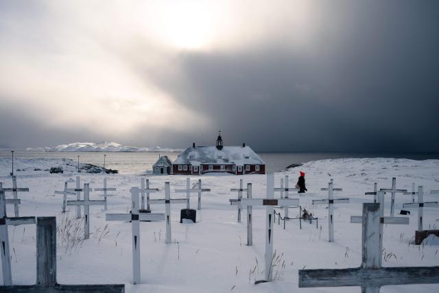 This photograph shows a cemetery and a church lit by sunlight breaking through storm clouds in the background, in Nuuk, Greenland, on March 4, 2026. (Photo by Florent VERGNES / AFP)
