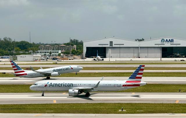 (FILES) An American Airlines plane takes off as another taxis to the runway at Miami International AirPort (MIA) on July 24, 2025. The US Department of Transportation on March 4, 2026 authorized an American Airlines (AA) subsidiary to operate direct flights to the Venezuelan cities of Caracas and Maracaibo from Miami, two months after Washington deposed the country's leader. Envoy Air, a wholly-owned AA subsidiary, is authorized to operate the flights for a two-year period, after applying for the permit on February 13, the US Department of Transportation said in a notice. (Photo by Daniel SLIM / AFP)