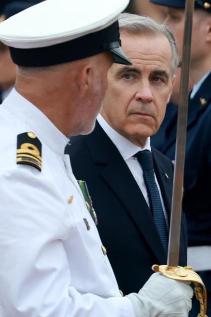 Canadian Prime Minister Mark Carney (R) inpects guard of honour in Canberra on March 5, 2026, during his official visit to Australia. (Photo by DAVID GRAY / AFP)