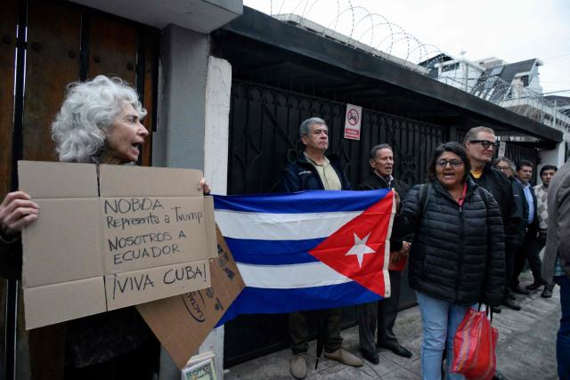 Former Ecuadorian ambassador to Cuba (2017-2019) Maria Augusta Calle (L) protests alongside supporters of the Cuban government as they hold a Cuban flag outside the Cuban embassy in Quito on March 4, 2026. Ecuador ordered the expulsion of Cuba's ambassador to Quito, giving him and the rest of his embassy staff 48 hours to leave the country, the foreign ministry announced. (Photo by Rodrigo BUENDIA / AFP)