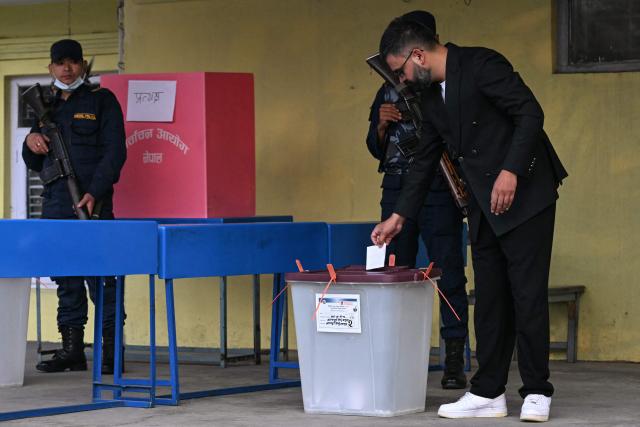 Rastriya Swatantra Party (RSP) election candidate Balendra Shah (R) casts his ballots as he votes at a polling station during Nepal's parliamentary election in Kathmandu on March 5, 2026. Nepal voted on March 5 for a new parliament, six months after deadly anti-corruption protests toppled the government -- a high-stakes showdown between an entrenched old guard and a powerful youth movement. (Photo by TAUSEEF MUSTAFA / AFP)