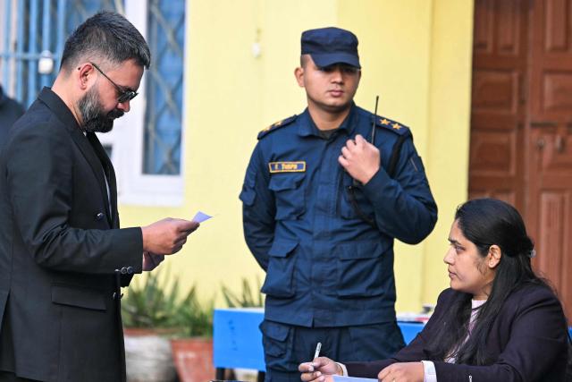 Rastriya Swatantra Party (RSP) election candidate Balendra Shah (L) waits to vote at a polling station during Nepal's parliamentary election in Kathmandu on March 5, 2026. Nepal voted on March 5 for a new parliament, six months after deadly anti-corruption protests toppled the government -- a high-stakes showdown between an entrenched old guard and a powerful youth movement. (Photo by TAUSEEF MUSTAFA / AFP)