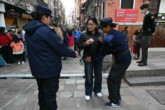 A member of security frisks a woman as she arrives to vote at a polling station during Nepal's parliamentary election in Kathmandu on March 5, 2026. Nepal voted on March 5 for a new parliament, six months after deadly anti-corruption protests toppled the government -- a high-stakes showdown between an entrenched old guard and a powerful youth movement. (Photo by TAUSEEF MUSTAFA / AFP)