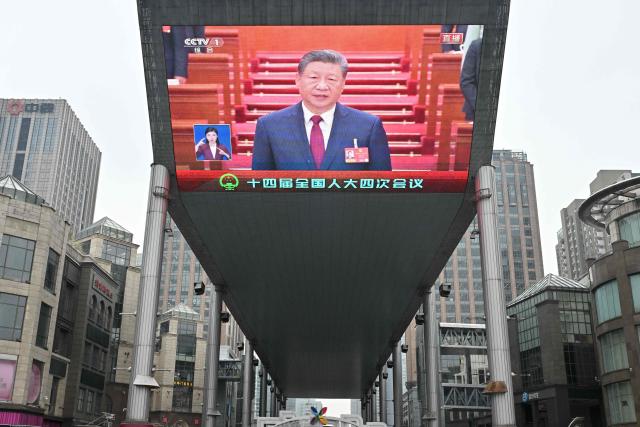 A screen shows Chinese President Xi Jinping during the opening session of the National People’s Congress (NPC) at the Great Hall of the People, in Beijing on March 5, 2026. (Photo by ADEK BERRY / AFP)