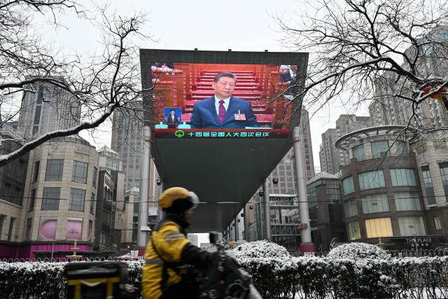 A screen shows Chinese President Xi Jinping during the opening session of the National People’s Congress (NPC) at the Great Hall of the People, in Beijing on March 5, 2026. (Photo by ADEK BERRY / AFP)