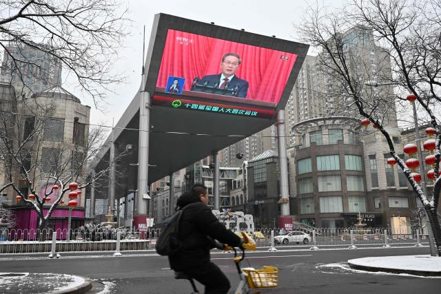 A screen shows Chinese Premier Li Qiang delivering a work report during the opening session of the National People’s Congress (NPC) at the Great Hall of the People, in Beijing on March 5, 2026. (Photo by ADEK BERRY / AFP)