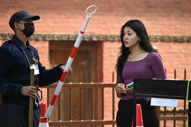 A woman arrives to cast her vote at a polling station during Nepal's parliamentary election in Kathmandu on March 5, 2026. Nepal voted on March 5 for a new parliament, six months after deadly anti-corruption protests toppled the government -- a high-stakes showdown between an entrenched old guard and a powerful youth movement. (Photo by TAUSEEF MUSTAFA / AFP)