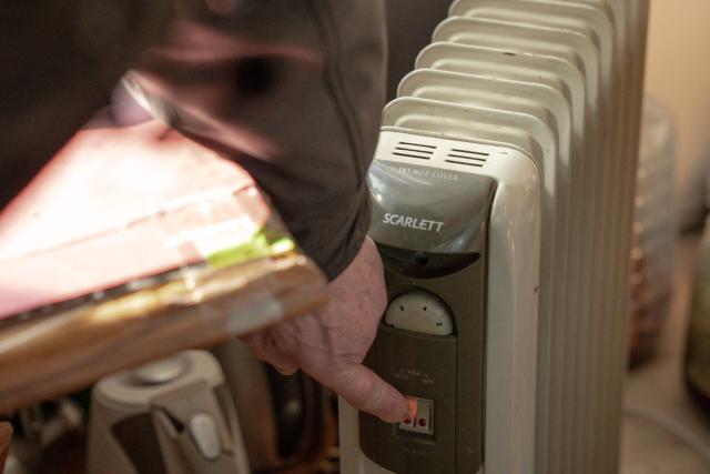 Grygory Gladysh, 79, the sole remaining resident of a heavily damaged 16-storey apartment building on the outskirts of Kharkiv, turns on a heater at his apartment where he has been living despite the lack of heating and water supply, on February 27, 2026, amid the Russian invasion of Ukraine. While millions of Ukrainians have been displaced internally or sought refuge abroad since the war began, many in dangerous areas are staying put, particularly elderly residents who lack the means or motivation to leave. (Photo by Ivan SAMOILOV / AFP)