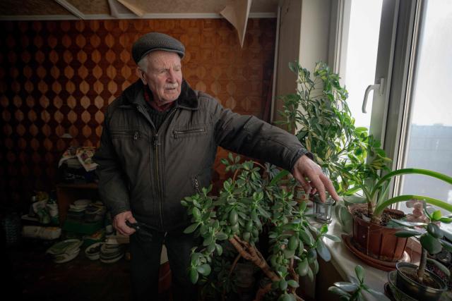 Grygory Gladysh, 79, the sole remaining resident of a heavily damaged 16-storey apartment building on the outskirts of Kharkiv, surveys a damage to his apartment where he has been living despite the lack of heating and water supply, on February 27, 2026, amid the Russian invasion of Ukraine. While millions of Ukrainians have been displaced internally or sought refuge abroad since the war began, many in dangerous areas are staying put, particularly elderly residents who lack the means or motivation to leave. (Photo by Ivan SAMOILOV / AFP)
