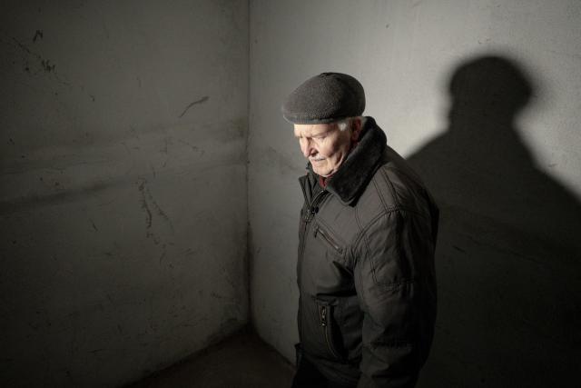 Grygory Gladysh, 79, the sole remaining resident of a heavily damaged 16-storey apartment building on the outskirts of Kharkiv, walks up a stairway to his apartment where he has been living despite the lack of heating and water supply, on February 27, 2026, amid the Russian invasion of Ukraine. While millions of Ukrainians have been displaced internally or sought refuge abroad since the war began, many in dangerous areas are staying put, particularly elderly residents who lack the means or motivation to leave. (Photo by Ivan SAMOILOV / AFP)