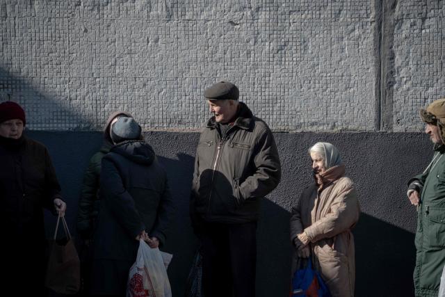 Grygory Gladysh (?), 79, the sole remaining resident of a heavily damaged 16-storey apartment building on the outskirts of Kharkiv, waits in line for hot meal distribution with other local residents, on February 27, 2026, amid the Russian invasion of Ukraine. While millions of Ukrainians have been displaced internally or sought refuge abroad since the war began, many in dangerous areas are staying put, particularly elderly residents who lack the means or motivation to leave. (Photo by Ivan SAMOILOV / AFP)