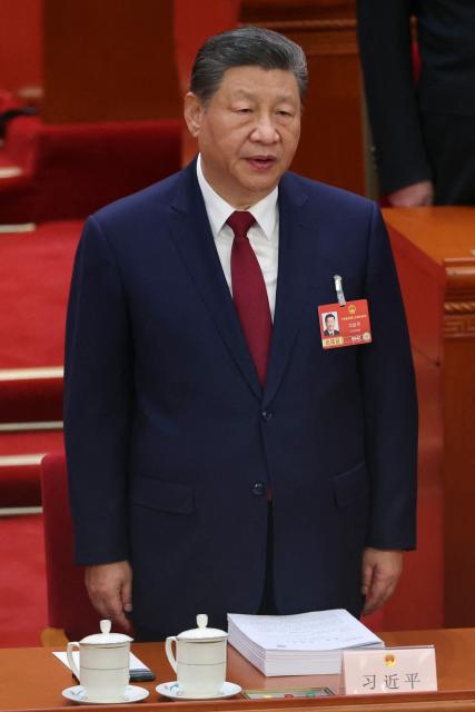 Chinese President Xi Jinping sings the national anthem during the opening session of the National People's Congress (NPC) at the Great Hall of the People in Beijing on March 5, 2026. (Photo by FLORENCE LO / POOL / AFP)