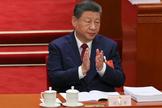 Chinese President Xi Jinping applauds during the opening session of the National People's Congress (NPC) at the Great Hall of the People in Beijing on March 5, 2026. (Photo by FLORENCE LO / POOL / AFP)