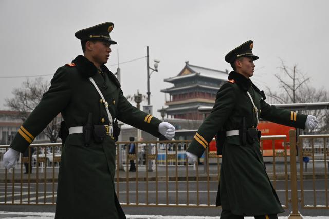Chinese paramilitary policemen patrol near the Great Hall of the People, venue for the opening session of the National People's Congress (NPC), in Beijing on March 5, 2026. (Photo by Pedro PARDO / AFP)