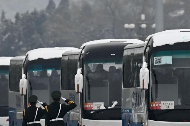 Delegates aboard buses leave the Great Hall of the People after the opening session of the National People's Congress (NPC) in Beijing on March 5, 2026. (Photo by Pedro PARDO / AFP)