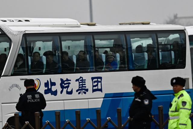 Delegates aboard buses leave the Great Hall of the People after the opening session of the National People's Congress (NPC) in Beijing on March 5, 2026. (Photo by Pedro PARDO / AFP)