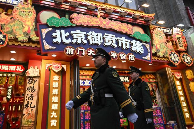 Chinese paramilitary policemen patrol on a street outside the Great Hall of the People, venue for the opening session of the National People's Congress (NPC), in Beijing on March 5, 2026. (Photo by Pedro PARDO / AFP)