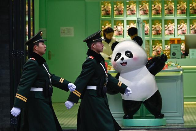 Chinese paramilitary policemen patrol on a street outside the Great Hall of the People, venue for the opening session of the National People's Congress (NPC), in Beijing on March 5, 2026. (Photo by Pedro PARDO / AFP)