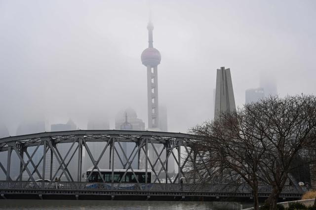 A bus drives on a bridge over the Suzhou River as the Oriental Pearl Tower is seen behind in Shanghai on March 5, 2026. (Photo by Jade GAO / AFP)