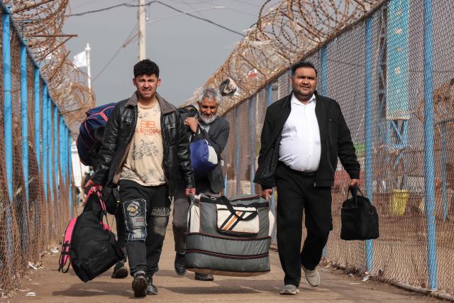 Afghan nationals walk with their belongings upon their arrival from Iran at the Islam Qala border crossing between Afghanistan and Iran in Herat province on March 5, 2026. Since US and Israeli strikes on February 28 triggered a regional war, Afghans crossing the border said they had left a frightening situation behind them. (Photo by Mohsen KARIMI / AFP)