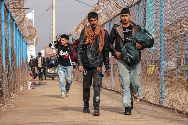 Afghan nationals walk with their belongings upon their arrival from Iran at the Islam Qala border crossing between Afghanistan and Iran in Herat province on March 5, 2026. Since US and Israeli strikes on February 28 triggered a regional war, Afghans crossing the border said they had left a frightening situation behind them. (Photo by Mohsen KARIMI / AFP)