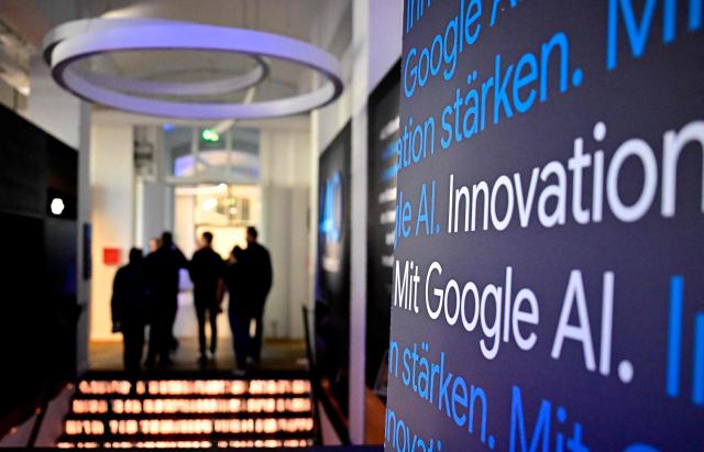Journalists walk through a presentation of a Google AI-Centre during the opening in Berlin on March 5, 2026. Google opens an AI centre in Berlin, the latest sign of Europe's deepening reliance on US firms in cutting edge technologies despite the continent's stated aim to catch up with its rivals. Germany's ministry for digital affairs told AFP the centre will bring together cloud computing and data infrastructure, "AI development" operations as well as a space for cooperation between start-ups and research centres. (Photo by Tobias SCHWARZ / AFP)