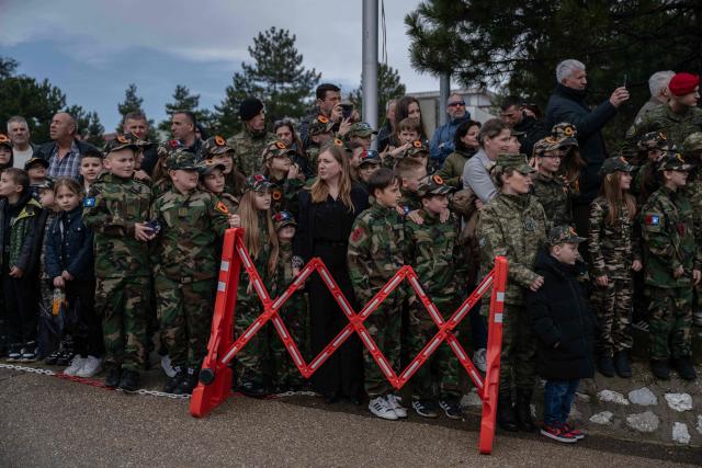 Kids wearing caps with the emblem of the Kosovo Security Force (KSF) take part in a ceremony marking the 28th anniversary of the killing of Kosovo Liberation Army (KLA) founding member and commander Adem Jashari, in Pristina on March 5, 2026. Jashari, seen as the "father of the KLA", was among 45 members of his family killed by Serb security forces in the village of Prekaz some 50 km west of the Kosovo capital Pristina, sparking a full-blown rebel insurgency. (Photo by Armend NIMANI / AFP)