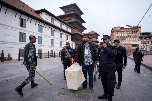 Security personnel escort as electoral officials carry ballot boxes to the counting centre after voting ends at a polling station during Nepal's general election in Kathmandu on March 5, 2026. Nepal voted on March 5 for a new parliament in a high-stakes showdown between an entrenched old guard and a powerful youth movement, six months after deadly anti-corruption protests toppled the government. (Photo by Prabin RANABHAT / AFP)