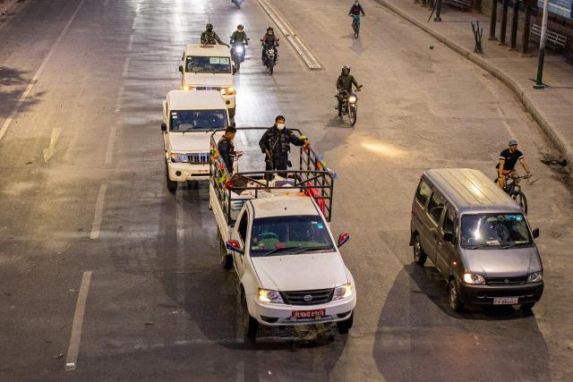 Security personnel escort electoral officials carrying ballot boxes to the counting centre after voting ends at a polling station during Nepal's general election in Kathmandu on March 5, 2026. Nepal voted on March 5 for a new parliament in a high-stakes showdown between an entrenched old guard and a powerful youth movement, six months after deadly anti-corruption protests toppled the government. (Photo by Prabin RANABHAT / AFP)