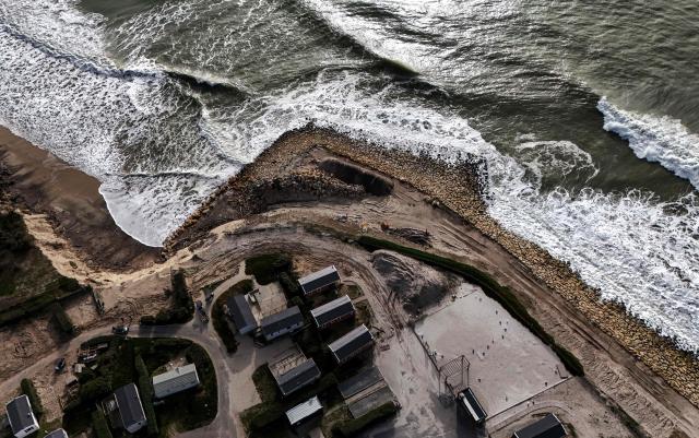 This aerial photograph shows waves breaking on a stonework aimed at protecting the bungalows of a camp site along the Atlantic Ocean in Soulac-sur-Mer, south-western France on March 4, 2026. Severe winter storms seriously damaged the coastline of the Nouvelle-Aquitaine region with coastal erosion triggering the retreat of the coastline by several meters at places and threatening a camp site in Soulac-sur-Mer. (Photo by Christophe ARCHAMBAULT / AFP)