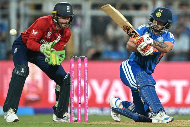 India's Ishan Kishan (R) plays a shot as England's wicketkeeper Jos Buttler watches during the 2026 ICC Men's T20 Cricket World Cup semi-final match between India and England at the Wankhede Stadium in Mumbai on March 5, 2026. (Photo by Punit PARANJPE / AFP)