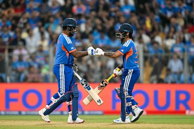 India's Sanju Samson (L) and Ishan Kishan bump their fists during the 2026 ICC Men's T20 Cricket World Cup semi-final match between India and England at the Wankhede Stadium in Mumbai on March 5, 2026. (Photo by Indranil MUKHERJEE / AFP)