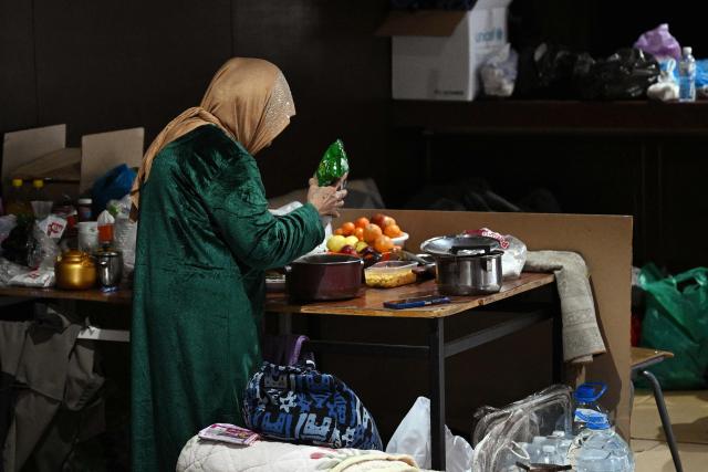A women prepares food at a school transformed into a shelter for displaced people in the town of Dekwaneh north of Beirut on March 5, 2026. Israel bombarded Lebanon on March 2, expanding the conflict across the region after the massive Israel-US attack on Iran that the US president launched to topple Tehran's ruling clerics, and killing their supreme leader on February 28. (Photo by Joseph EID / AFP)