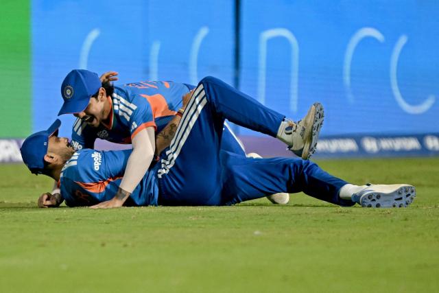 India's Axar Patel (L) celebrates with Ishan Kishan after taking a catch to dismiss England's captain Harry Brook during the 2026 ICC Men's T20 Cricket World Cup semi-final match between India and England at the Wankhede Stadium in Mumbai on March 5, 2026. (Photo by Indranil MUKHERJEE / AFP)