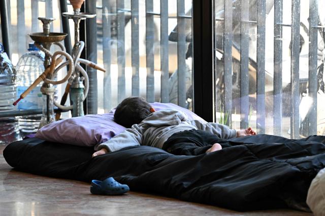 A child sleeps at a school transformed into a shelter for displaced people in the town of Dekwaneh north of Beirut on March 5, 2026. Israel bombarded Lebanon on March 2, expanding the conflict across the region after the massive Israel-US attack on Iran that the US president launched to topple Tehran's ruling clerics, and killing their supreme leader on February 28. (Photo by Joseph EID / AFP)