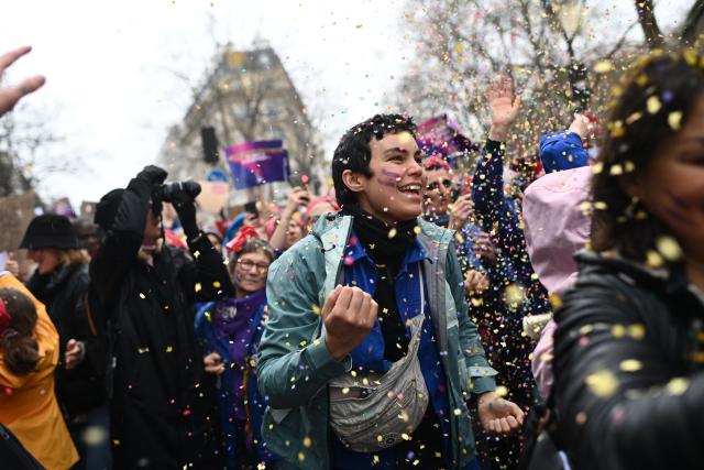 (FILES) Women play with confettis as they take part in a rally to mark the International Women's Day in Paris, on March 8, 2023, one day after the nationwide rallies organized since the start of the year against French President's pension reform and its postponement of the legal retirement age from 62 to 64. The International Women's Rights Day will fall on March 8, 2026. (Photo by Christophe ARCHAMBAULT / AFP)