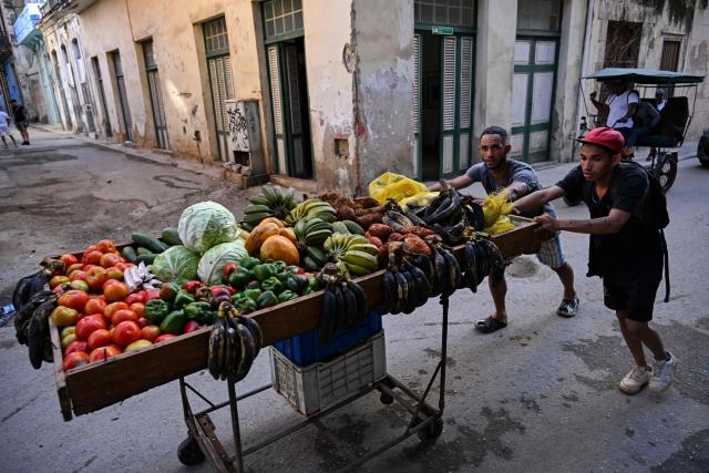 Fruit and vegetable vendors push their cart down a street after a power outage in Havana on March 5, 2026. Cuban authorities said on March 5, 2026 that electricity is slowly coming back to end a blackout that hit two-thirds of the beleaguered communist nation and stemmed from a lack of fuel under US pressure. (Photo by YAMIL LAGE / AFP)