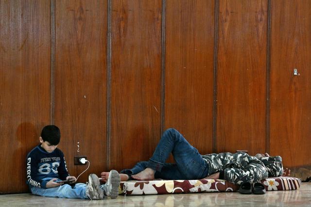 People sit inside a school transformed into a shelter for displaced people in the town to Dekwaneh, north of Beirut on March 5, 2026. Israel bombarded Lebanon on March 2, expanding the conflict across the region after the massive Israel-US attack on Iran that the US president launched to topple Tehran's ruling clerics, and killing their supreme leader on February 28. (Photo by Joseph EID / AFP)