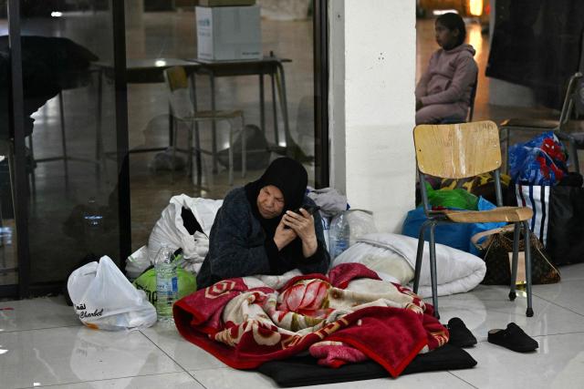 A woman listens to her phone inside a school transformed into a shelter for displaced people in the town to Dekwaneh, north of Beirut on March 5, 2026. Israel bombarded Lebanon on March 2, expanding the conflict across the region after the massive Israel-US attack on Iran that the US president launched to topple Tehran's ruling clerics, and killing their supreme leader on February 28. (Photo by Joseph EID / AFP)