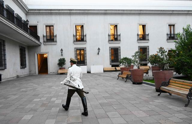 A member of the Presidential Guard walks through the Patio de los Naranjos at La Moneda Palace ahead of the arrival of the new President Jose Antonio Kast, in Santiago on March 3, 2026. Chile's presidential palace La Moneda is being prepared to serve as a residence again after nearly 70 years, with president-elect Jose Antonio Kast scheduled to move in on March 11. Kast will be the first head of state to live in the neoclassical Santiago landmark since 1958. (Photo by Rodrigo ARANGUA / AFP)