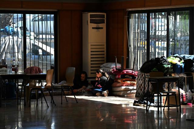 People sit inside a school transformed into a shelter for displaced people in the town to Dekwaneh, north of Beirut on March 5, 2026. Israel bombarded Lebanon on March 2, expanding the conflict across the region after the massive Israel-US attack on Iran that the US president launched to topple Tehran's ruling clerics, and killing their supreme leader on February 28. (Photo by Joseph EID / AFP)