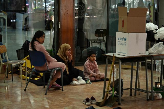 People sit inside a school transformed into a shelter for displaced people in the town to Dekwaneh, north of Beirut on March 5, 2026. Israel bombarded Lebanon on March 2, expanding the conflict across the region after the massive Israel-US attack on Iran that the US president launched to topple Tehran's ruling clerics, and killing their supreme leader on February 28. (Photo by Joseph EID / AFP)