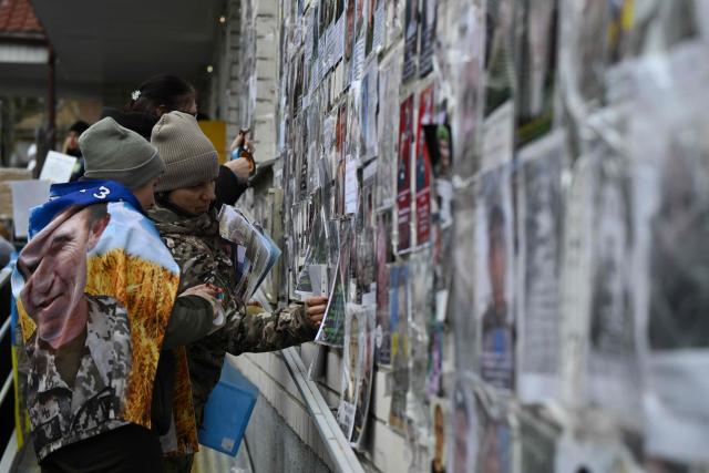 Families place portraits their missing or captured relatives and friends before the arrival of released Ukrainian prisoners of war (POW) after a prisoners exchange in the Chernigiv region on March 5, 2026, amid the Russian invasion of Ukraine. Ukraine and Russia each freed 200 prisoners of war, the first part of an exchange that will see them swap 500 people each in total, officials said. (Photo by Genya SAVILOV / AFP)