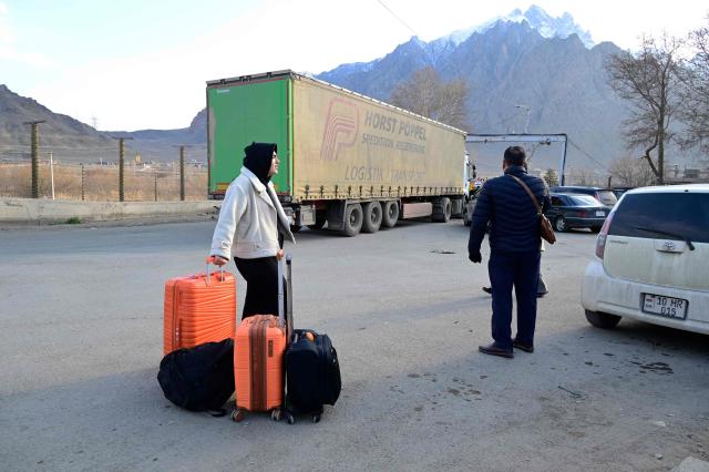 Iranian refugees cross the border from Iran to Armenia at a border check point in the southern Armenian town of Gyumri, on March 5, 2026, amid the Middle East war. The United States and Israel began a sweeping military campaign against Iran, targeting missile facilities, naval assets and other infrastructure, with strikes triggering retaliatory attacks across the region. (Photo by KAREN MINASYAN / AFP)