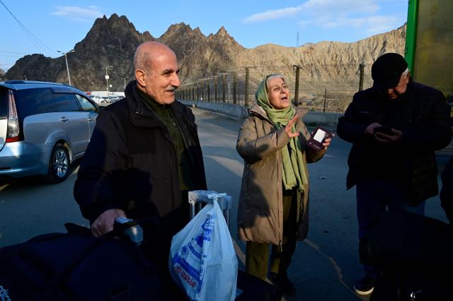 Iranian refugees react after crossing the border from Iran to Armenia at a border check point in the southern Armenian town of Gyumri, on March 5, 2026, amid the Middle East war. The United States and Israel began a sweeping military campaign against Iran, targeting missile facilities, naval assets and other infrastructure, with strikes triggering retaliatory attacks across the region. (Photo by KAREN MINASYAN / AFP)
