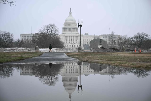 The US Capitol building is reflected in a pool of water from melted snow in Washington, DC, on March 5, 2026. (Photo by Brendan SMIALOWSKI / AFP)