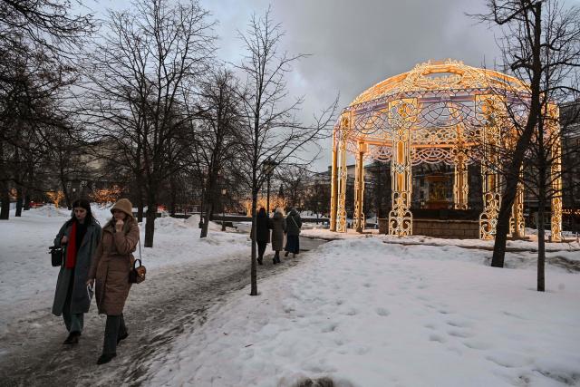 People walk on a street in central Moscow, on March 5, 2026. (Photo by Hector RETAMAL / AFP)