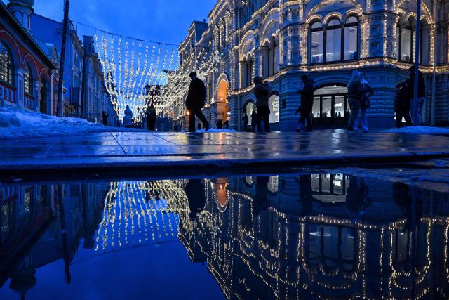 People walk on a street in central Moscow, on March 5, 2026. (Photo by Hector RETAMAL / AFP)