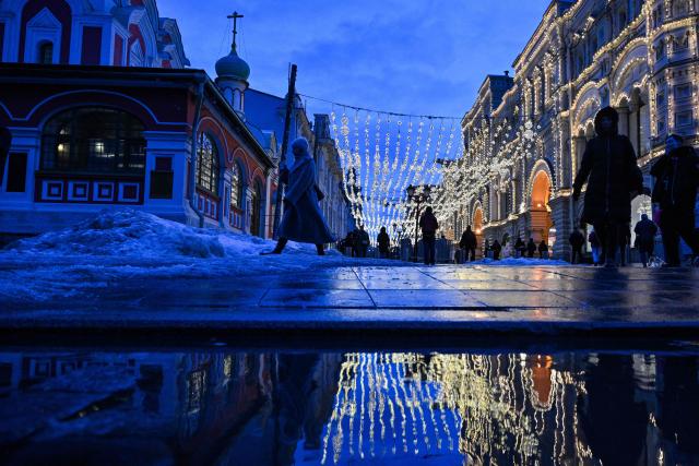 People walk on a street in central Moscow, on March 5, 2026. (Photo by Hector RETAMAL / AFP)